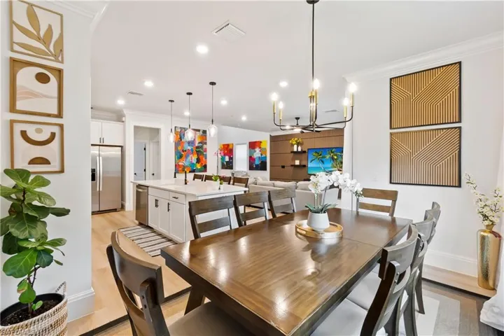 Dining area with crown molding, a chandelier, light wood-type flooring, and recessed lighting