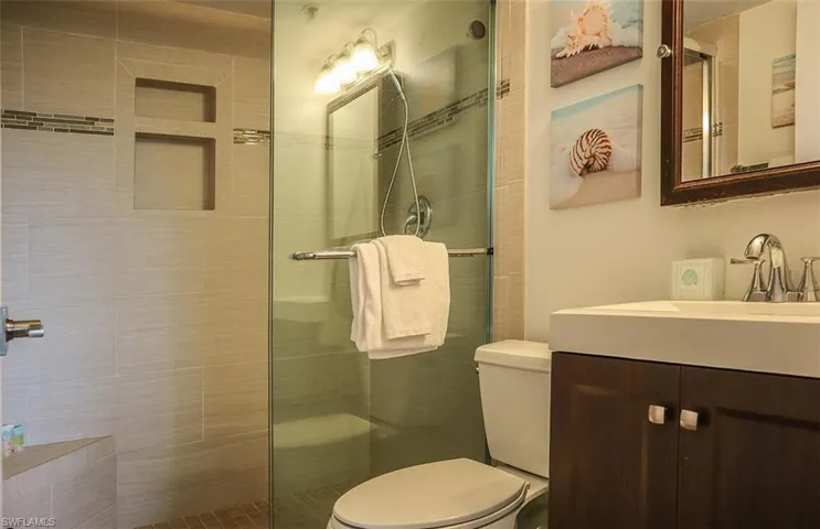 Bathroom with vanity, toilet, and a shower stall