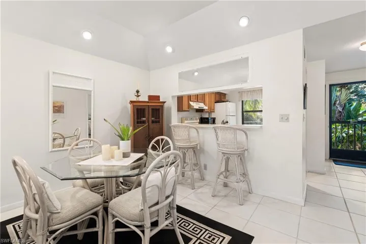 Tiled dining room with lofted ceiling
