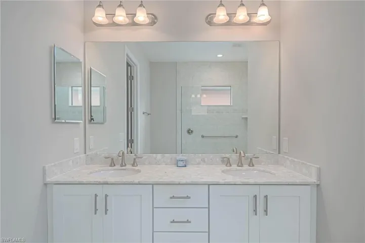 Bathroom featuring vanity and tiled shower
