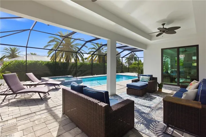 View of patio featuring a sunroom, an outdoor hangout area, a pool with connected hot tub, and a lanai