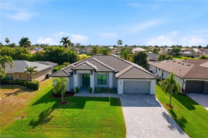 View of front of property featuring decorative driveway, a front yard, an attached garage, and a residential view
