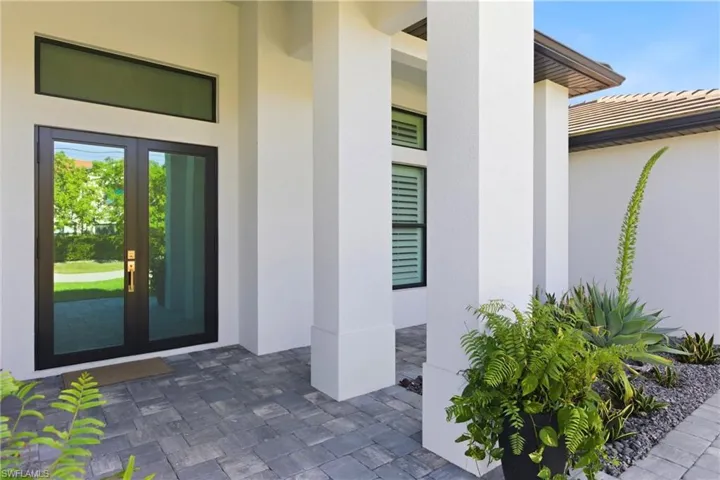 View of exterior entry featuring french doors and stucco siding