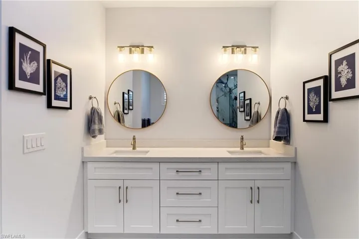 Bathroom featuring double vanity and baseboards
