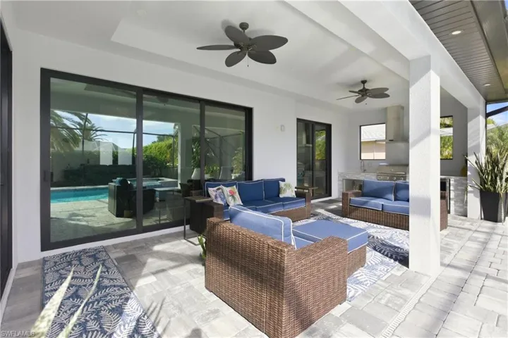 View of patio / terrace with ceiling fan, a hot tub, an outdoor kitchen, and an outdoor living space