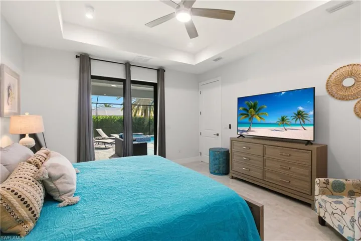 Bedroom featuring access to outside, a raised ceiling, a ceiling fan, and recessed lighting