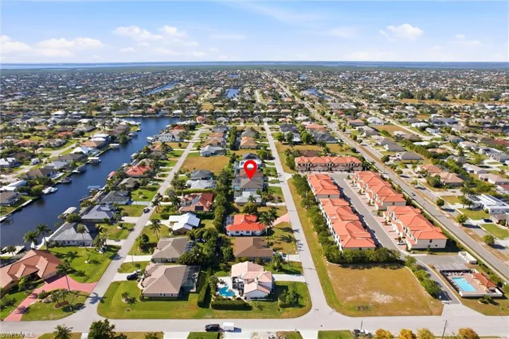 Aerial perspective of suburban area featuring a nearby body of water