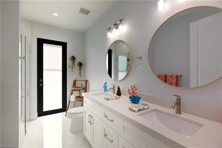 Bathroom featuring double vanity and an enclosed shower
