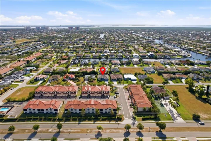 Aerial perspective of suburban area featuring a nearby body of water