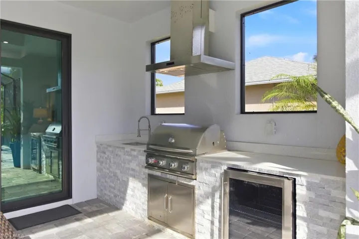 View of patio / terrace featuring an outdoor kitchen and beverage cooler