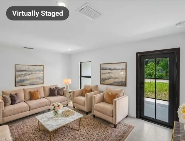 Bright living area featuring white walls, recessed lighting, and light-toned flooring