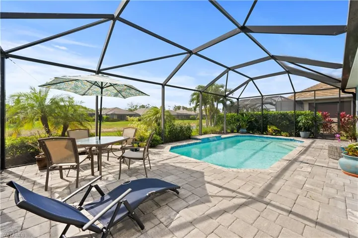 Pool with a lanai, outdoor dining space, and a patio area
