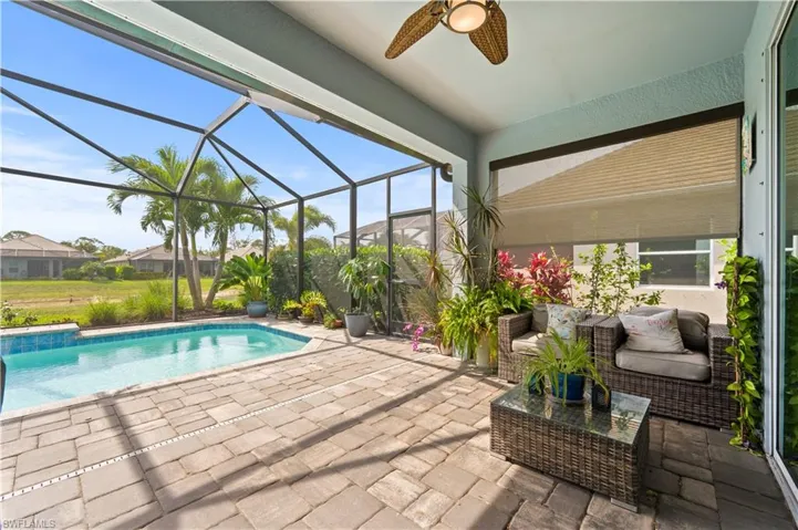 Outdoor pool featuring a patio area, a ceiling fan, and a lanai