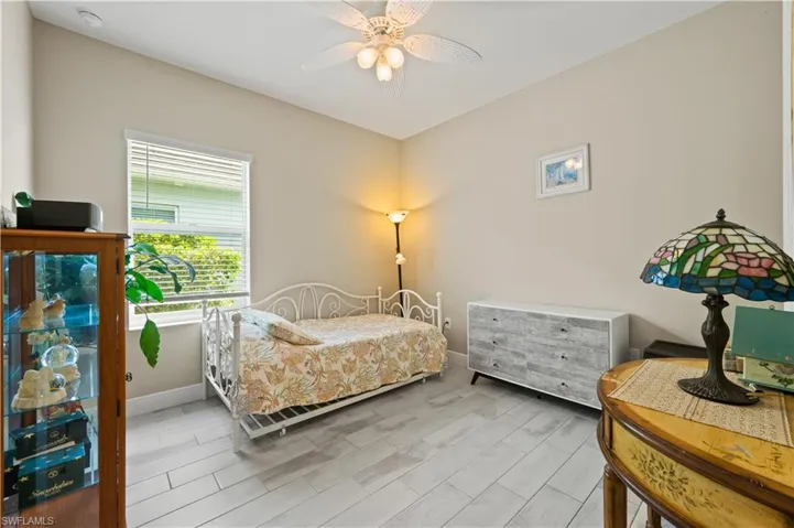Bedroom with light wood-style flooring, ceiling fan, and baseboards