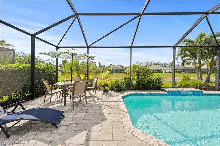 Outdoor pool featuring glass enclosure, a patio, and outdoor dining area