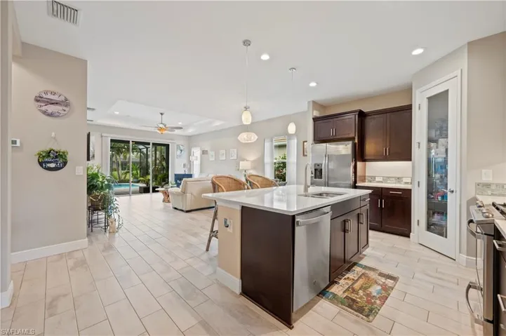 Kitchen with open floor plan, light countertops, visible vents, a tray ceiling, and stainless steel appliances