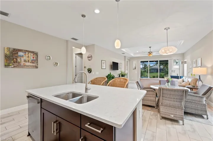 Kitchen with stainless steel dishwasher, visible vents, a sink, and dark brown cabinets