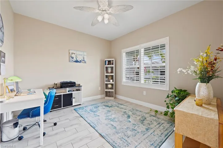Office featuring baseboards, a ceiling fan, and wood tiled floor