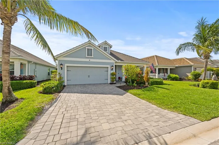 View of front of house featuring a garage, a front yard, and decorative driveway