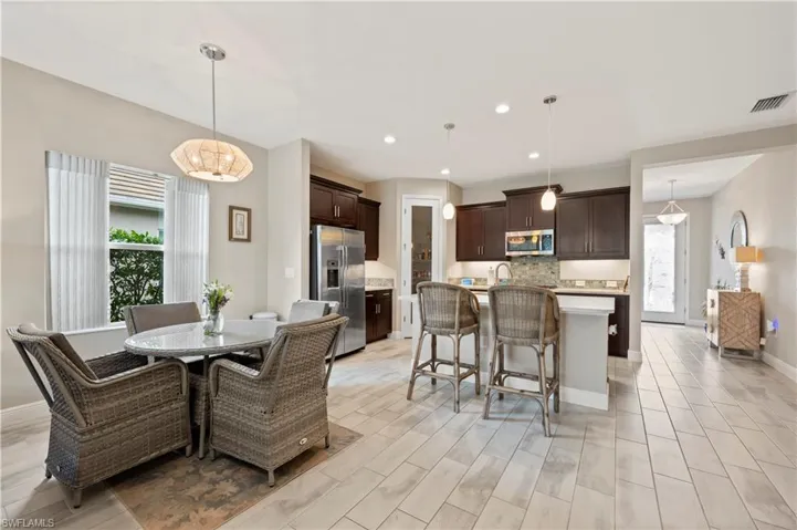 Dining area with light wood finished floors, baseboards, visible vents, and recessed lighting