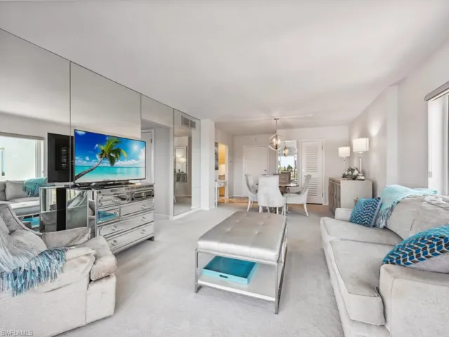 Carpeted living room with a chandelier and plenty of natural light