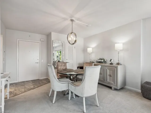 Dining room featuring light carpet and a notable chandelier