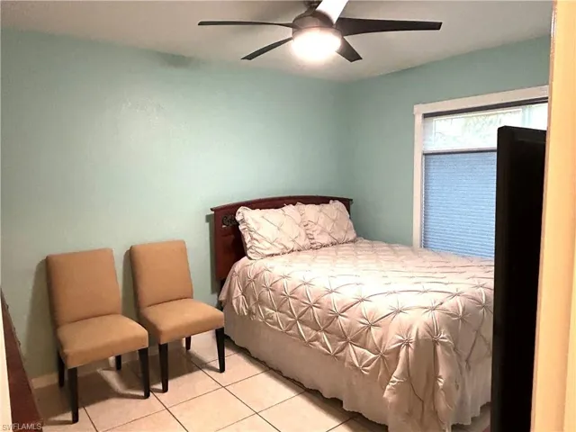 Bedroom with light tile patterned flooring and ceiling fan