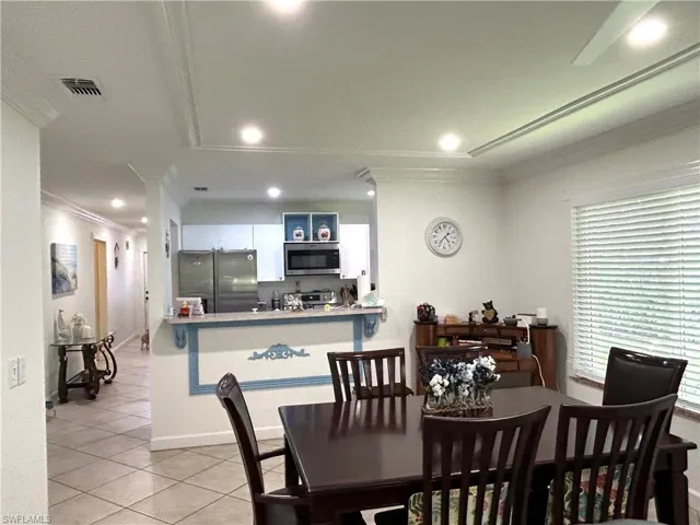 Dining room featuring ornamental molding, light tile patterned floors, and recessed lighting