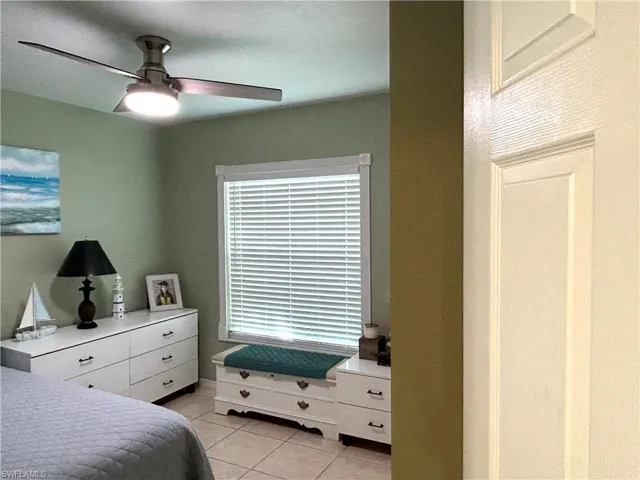 Bedroom with light tile patterned floors and ceiling fan