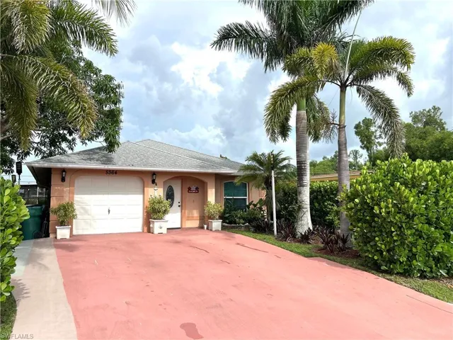 View of front of house featuring an attached garage, stucco siding, concrete driveway, and a shingled roof