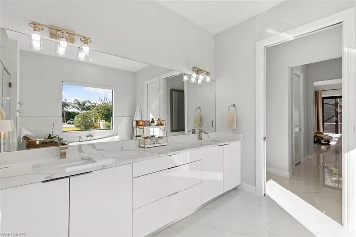 Full bathroom with light marble finish flooring and double vanity