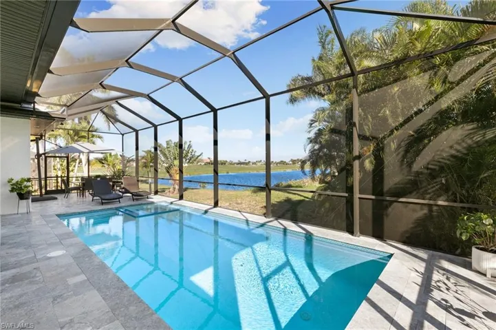 Swimming pool featuring a water view, a lanai, a sunroom, and a patio area
