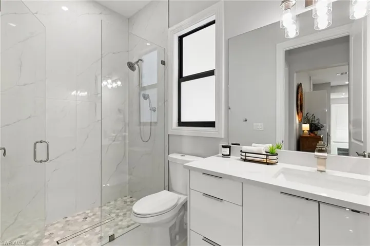 Full bath with vanity and a marble finish shower