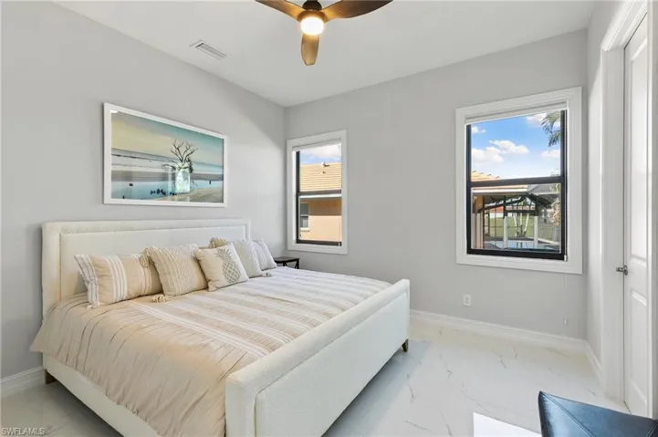 Bedroom with light marble finish floors and a ceiling fan