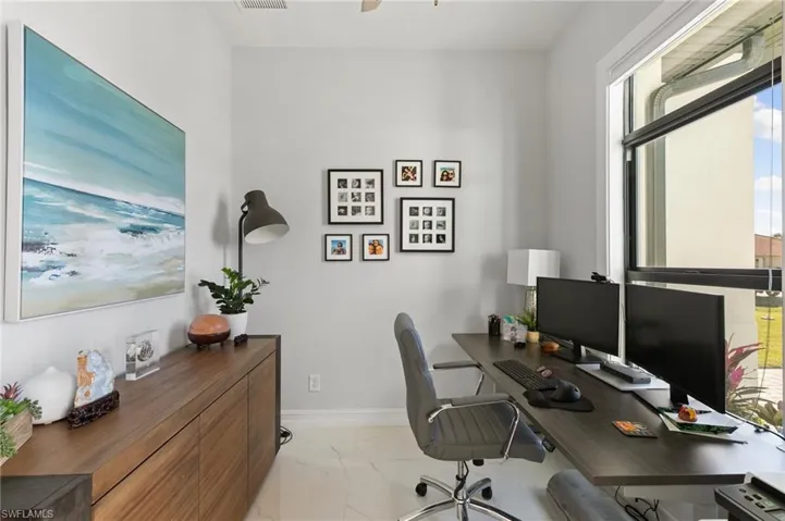 Office area featuring light marble finish floors and a ceiling fan