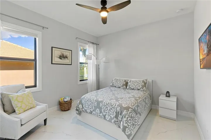 Bedroom featuring light marble finish flooring and ceiling fan