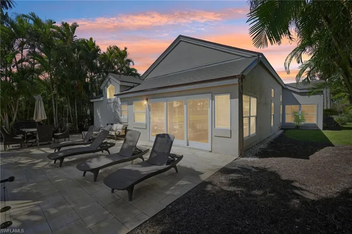 Back of property at dusk with a patio and stucco siding