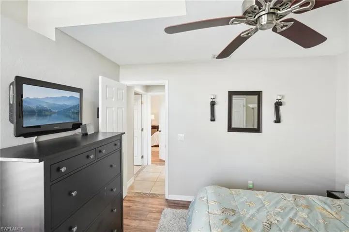 Bedroom featuring light wood-type flooring, a ceiling fan, and baseboards