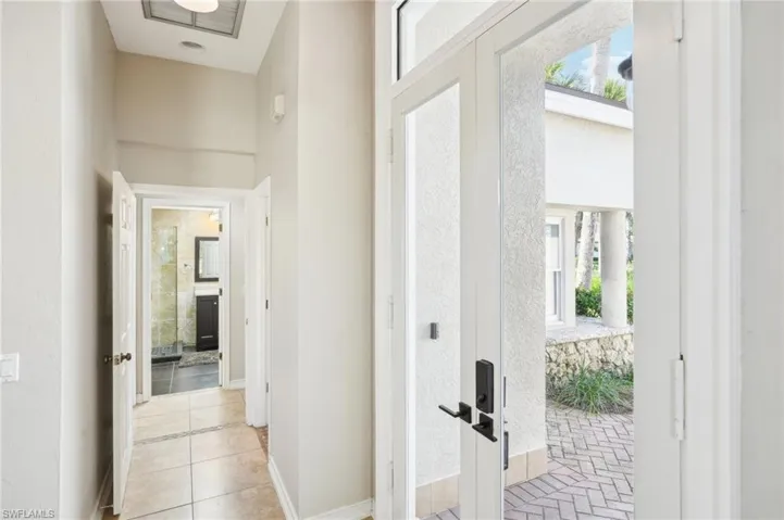 Hall featuring tile patterned floors, baseboards, and french doors