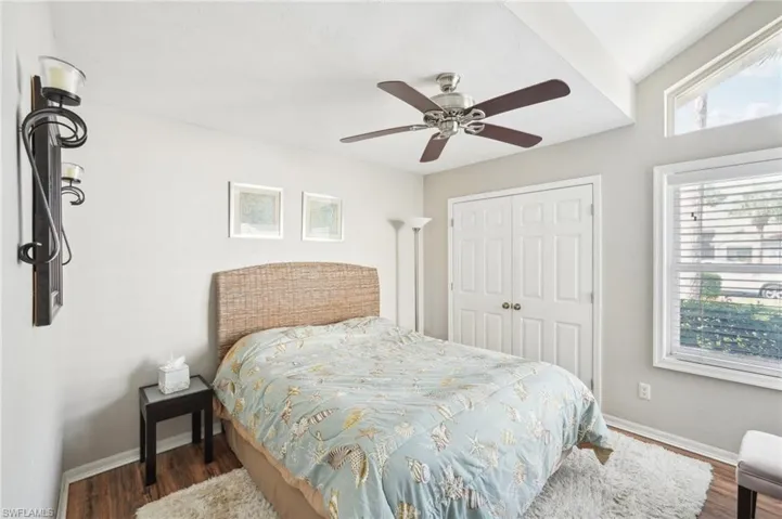 Bedroom with a closet, wood finished floors, a ceiling fan, and baseboards