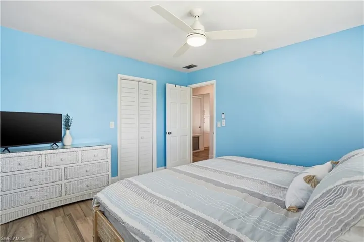 Bedroom with wood finished floors, ceiling fan, and a closet - Virtually Edited Image