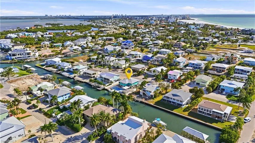 Aerial view of property's location featuring a nearby bay and Gulf and nearby suburban area - Virtually Edited Image