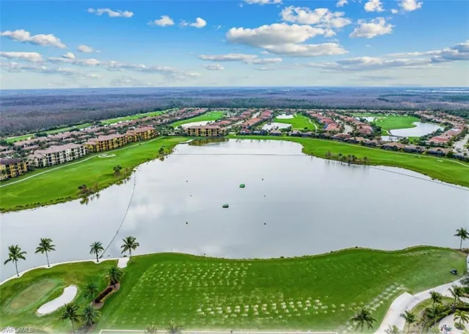 Aerial view of residential area with a golf club and a nearby body of water