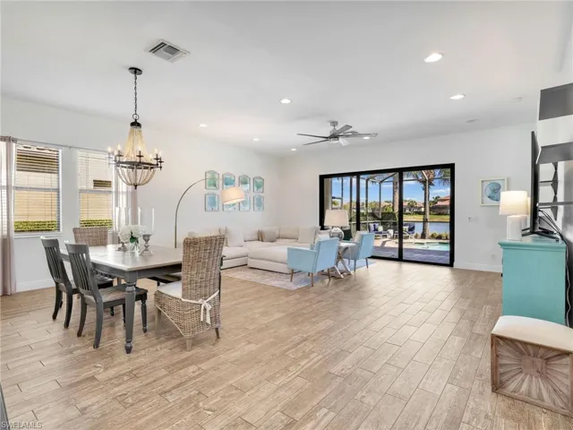 Dining space with ceiling fan, light wood-type flooring, recessed lighting, and a chandelier