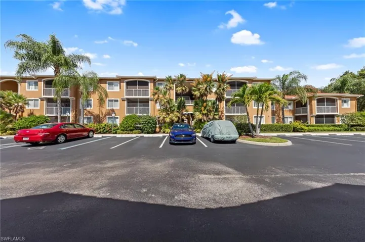 View of apartment building / complex featuring uncovered parking