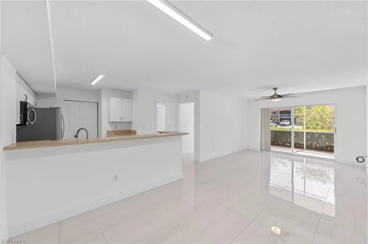 Unfurnished living room featuring baseboards and ceiling fan