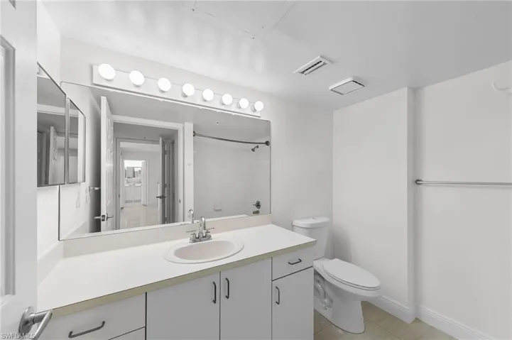 Bathroom with vanity, a tile shower, and light tile patterned floors