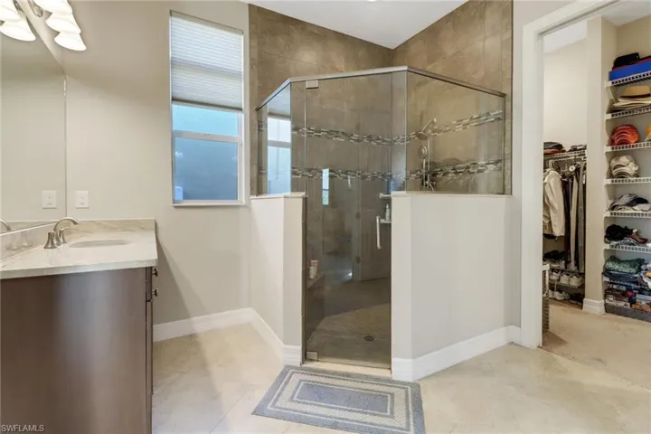 Master bath with shower tiled to ceiling, inlaid tile strips and seamless clear joints.