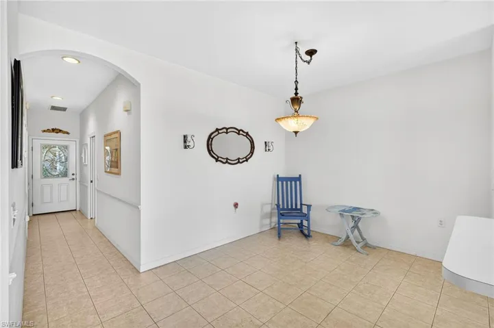 Unfurnished room with arched walkways, light tile patterned floors, and recessed lighting