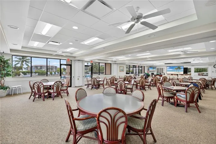 Dining space featuring a raised ceiling, a ceiling fan, light carpet, recessed lighting, and a drop ceiling
